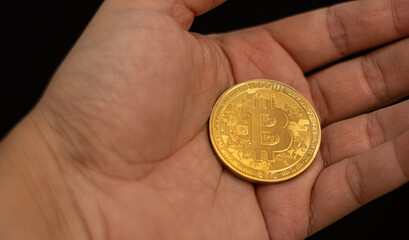 hand of a businessman holding bitcoin, symbol of future saving or investment bitcoin will become gold in the future
