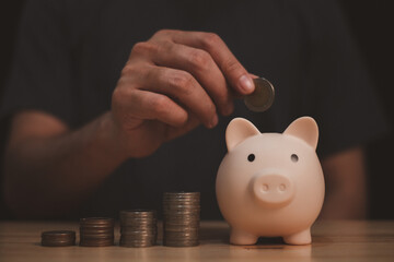 a man is under saving money coin in to piggy bank, symbol of financial management and future aim