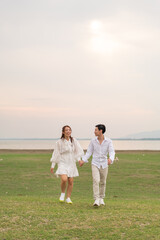 Happy young Asian couple in bride and groom clothing