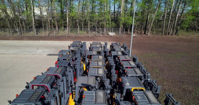 New Jac forklifts parked in a row for sale in a distribution center. Loading equipment shop. 