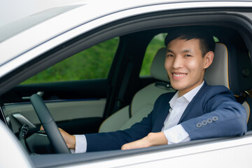 Asian business man smiling sit in their car. The concept of buying a car or renting a car