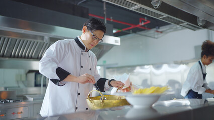 Male asian chef working at kitchen, He cooking food for customer. Chef, Lifestyle, Working, Teamwork and Chef table concept.