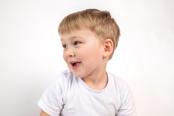 Close-up portrait of a cute smiling boy in a white T-shirt on a white background. Studio snapshot