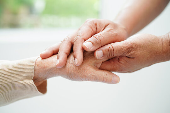 Caregiver holding hands Asian elderly woman patient, help and care in hospital.
