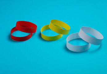 Red, yellow and white paper bracelets on a blue background