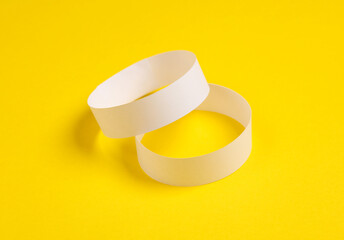 White paper bracelets on yellow background