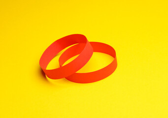 Red paper bracelets on yellow background