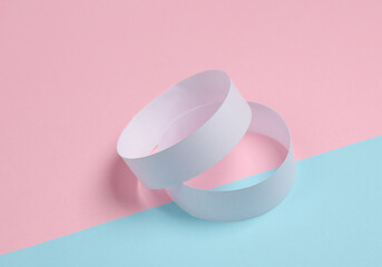 white paper bracelets on pink blue background