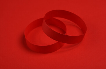 Red paper bracelets on red background