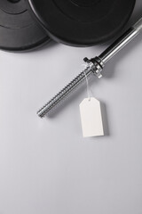 Barbell with price tag on gray background