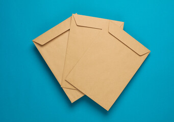 Craft postal envelopes on blue background