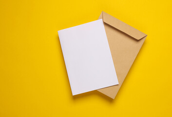 Craft postal envelope with white blank letter on yellow background