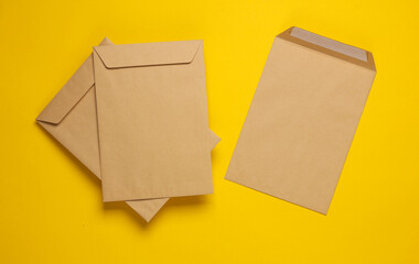 Craft postal envelopes on yellow background