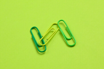 Pink paper clips on green background