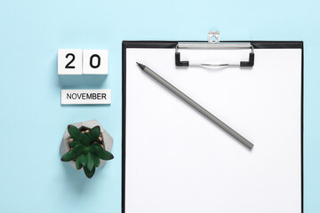 Business concept, planning, deadline. Block Calendar with date november 20 and clipboard on a blue background.