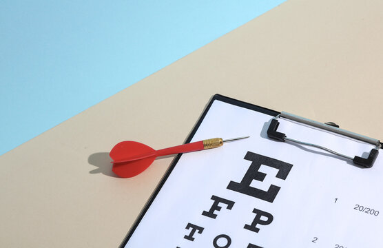 Darts and Eye test chart on blue beige background. Vision examination