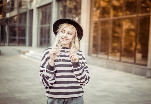 Portrait of a young charming woman in a sweater and hat outdoors