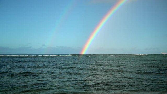 Slow Motion Beautiful View Of Rainbow In Sky By Wavy Sea - Oahu, Hawaii