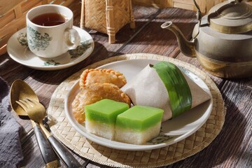 Malaysian local dishes with Nasi Lemak daun pisang (coconut rice milk), sweet slices of cake called...