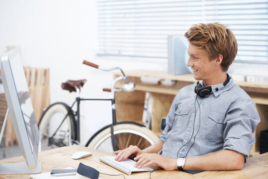 Man, Startup Office And Typing With Smile, Computer And Creativity For Post On Social Media Website. Young Businessman, Entrepreneur And Seo Expert On Web With Happiness At Small Business By Computer