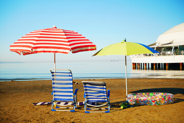 Two lounge chairs with sun umbrella on a sea beach,  idyllic tropical sand beach