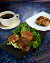 Breaded potato nuget, with orejona lettuce, with dry chile sauce, a coffee in the background