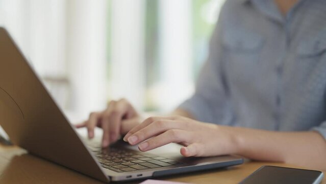 Young adult woman asia people happy work at coworking space table self study learn MBA class online course. Smart worker reskill upskill job searching data write plan on laptop. Urban modern workspace