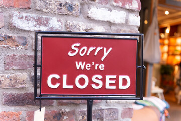 sorry we are closed sign hanging outside a restaurant, store, office or other