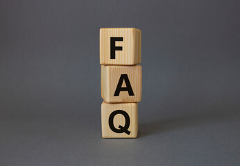 FAQ - Frequently Asked Questions symbol. Concept word FAQ on wooden cubes. Beautiful grey...