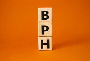 BPH - Benign Prostatic Hyperplasia symbol. Wooden cubes with word BPH. Beautiful orange background. Medical and BPH concept. Copy space.