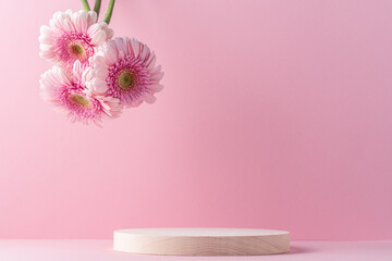 Wooden round podium pedestal cosmetic beauty product presentation empty mockup on  pink background with gerbera flowers