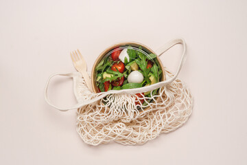 Cardboard bowl container with fresh caprese salad. Food delivery, zero waste, recycling packaging,...