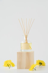 Aromatic air freshener on white background with yellow flower buds. Home comfort concept