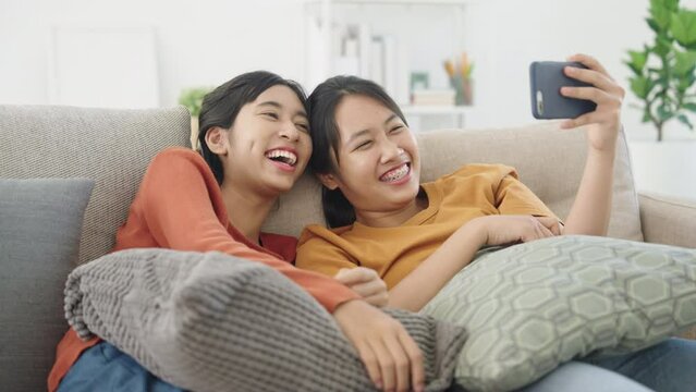 Asian two girl watch entertainment smartphone enjoyment at home morning