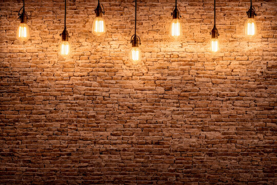 Concept vintage bulbs on brick wall background, copy space for text. Decorative incandescent bulbs in Edison style on brick wall background. Generative AI
