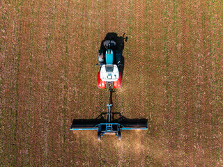 Tractor with a roller tillage on spring field. Aerial view of Soil rolling supports germination and...