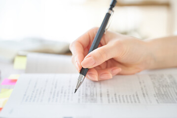 テキストを使って勉強する女性の手元