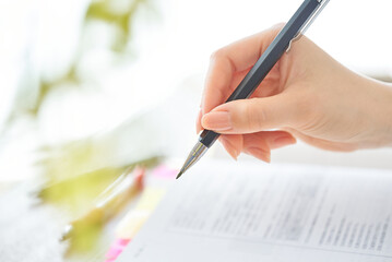テキストを使って勉強する女性の手元