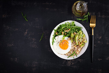 Breakfast oatmeal porridge with roasted eggs, kiwi, arugula and flax seeds. Healthy breakfast to lower cholesterol. Top view, flat lay