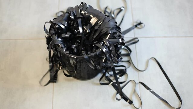 The tape from the video cassette is thrown into the wastebasket.