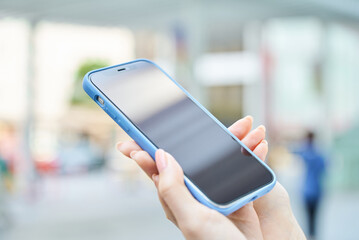 街角でスマートフォンを使う女性の手元