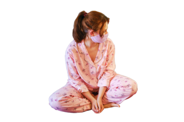 A woman sitting on a bed in quarantine, concept, isolated on a white background. A woman in a protective mask in quarantine during an illness with the Covid-19 flu virus