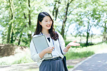 Fototapeta premium Business woman working in fresh green 新緑の中で仕事するビジネスウーマン