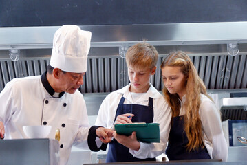 Chef teaching students how to cook in the kitchen.