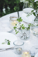 Rustic elegant eco friendly zero waste trendy wedding reception table decor with fresh spring apple cherry flowers in bloom. Beautiful marriage decoration, holiday event outdoors in the family garden