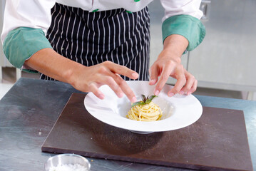 Obraz na płótnie Canvas Chef cooking spaghetti on a white plate.