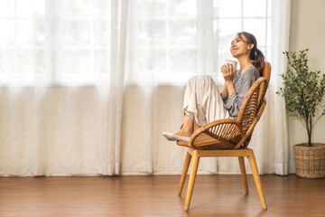 Fototapeta premium Portrait of smiling happy cheerful beauty pretty asian woman relaxing drinking and looking at cup of hot coffee or tea.Girl felling enjoy having breakfast in holiday morning vacation on bed at home