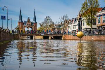 The famous Waterpoort gate in the port of Sneek with a sculpture Fortuna’s Fountain in the foreground, Friesland, Netherlands.