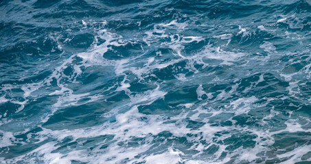 Ocean water background. Blue sea texture with waves and foam