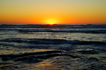 Obraz premium Coucher de soleil sur l'océan et les vagues de l'Atlantique